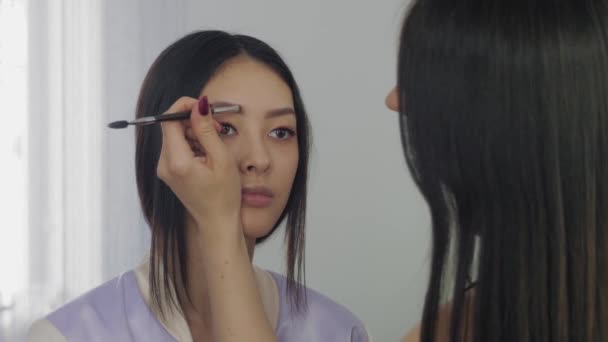 Jóvenes modelos asiáticos se enfrentan durante el proceso de maquillaje . — Vídeo de stock