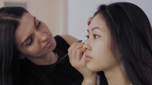 Jóvenes modelos asiáticos se enfrentan durante el proceso de maquillaje . — Vídeo de stock