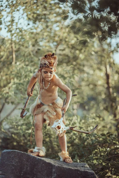 Caveman, manly boy with primitive weapon outdoors. Ancient prehistoric warrior. — Stock Image Caveman, manly boy with primitive weapon outdoors. Ancient prehistoric warrior. Stock Photo