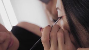Genç Asyalı modelleri yüz makyaj işlemi sırasında.