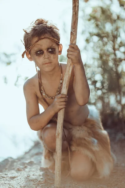 Söt grottman, manly pojke med personalen jakt utomhus. Forntida krigare — Stockfoto