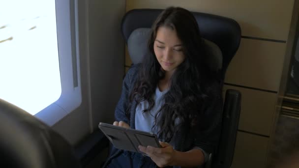 Młoda kobieta, jej komputera typu tablet podczas podróży pociągiem. Koncepcja aplikacji podróży — Wideo stockowe