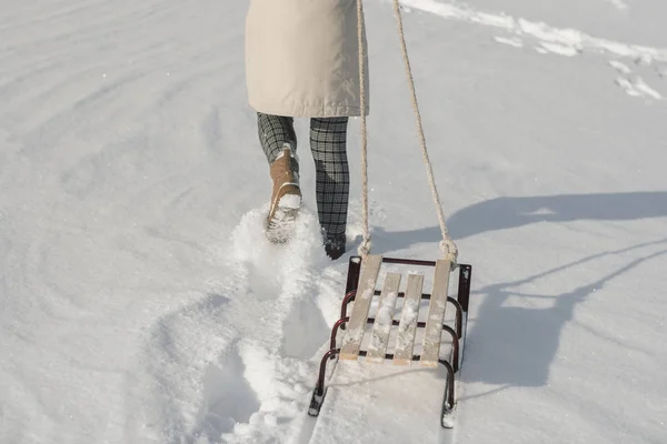 Зимові черевики на снігу біля санчаток з мотузкою . — стокове фото