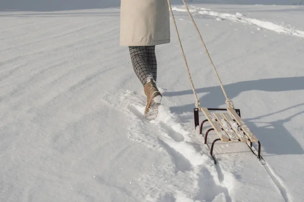 Botas de inverno na neve perto do trenó com corda . — Fotografia de Stock