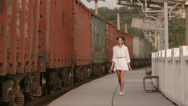 Woman walking near train rail on train station. Beauty, freedom, summer travel concept. — Stock Video