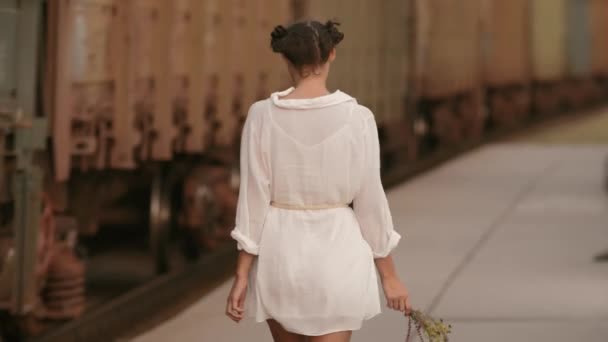 Vrouw lopen in de buurt van trein spoor op treinstation. Schoonheid, vrijheid, zomer reizen concept. — Stockvideo
