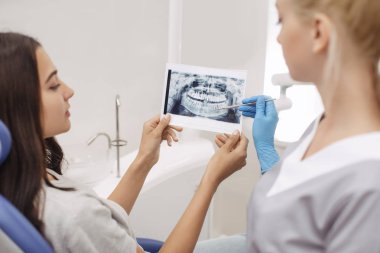 Diş hekimi gösteren x-ray görüntü hastaya
