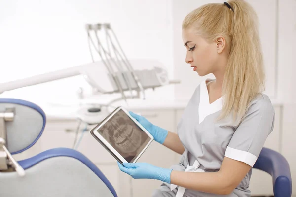 Dentist doctor using digital tablet against dental equipment. — Stock Photo, Image