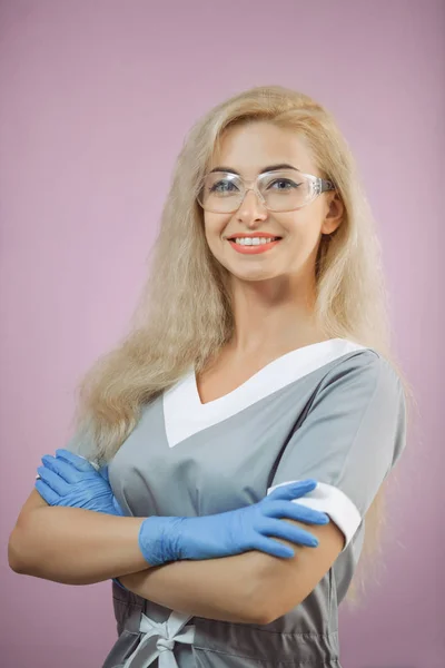 Porträt eines fröhlichen, glücklichen Arztes in grauer Uniform mit verschränkten Händen — Stockfoto