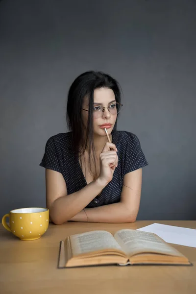 Beautiful young woman in glasses reading a book. — Stock Photo, Image