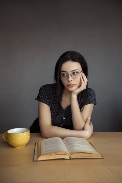 Beautiful young woman in glasses reading a book. — Stock Photo, Image