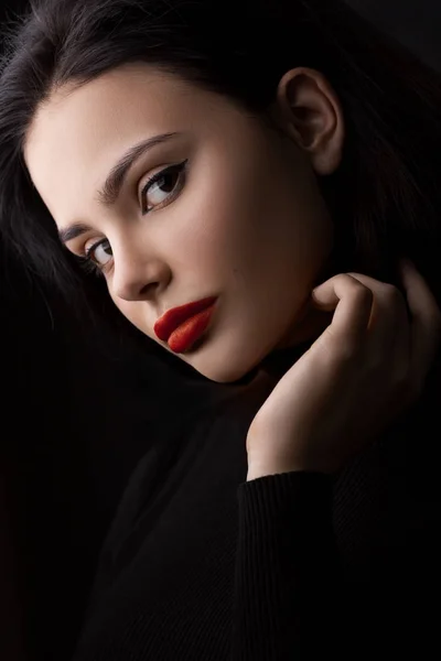 Краса жінки крупним планом портрет з ідеальною шкірою і макіяжем в чорному одязі на чорному тлі — стокове фото