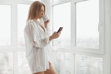 Güzel sarışın kız smartphone ve kahve kapalı.