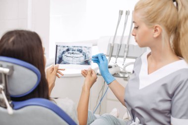 Diş hekimi gösteren x-ray görüntü hastaya
