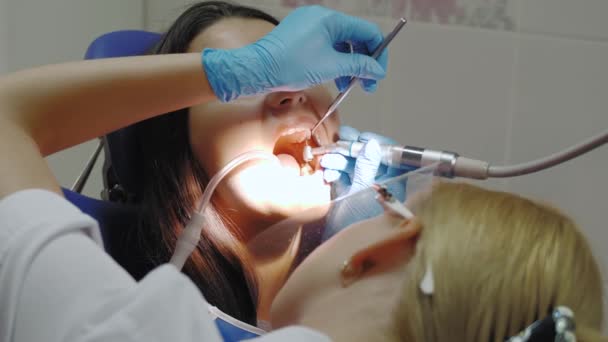 Dentista fazendo um tratamento odontológico em uma paciente do sexo feminino. — Vídeo de Stock