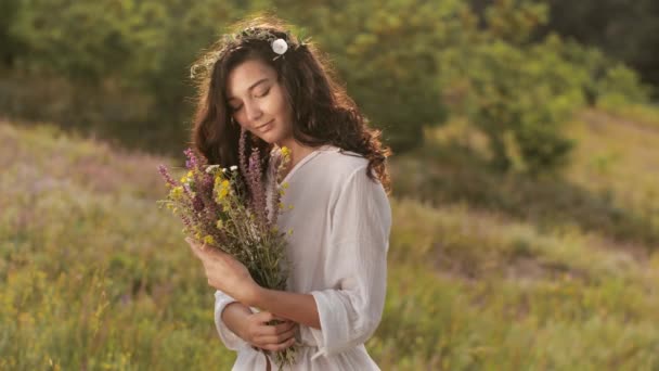 Fille beauté naturelle avec bouquet de fleurs en plein air dans le concept de plaisir de la liberté. Photo de portrait — Video