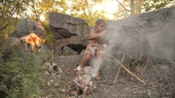 Mağara adamı, erkekçe çocuk kampında ilkel taş silah yapma — Stok video
