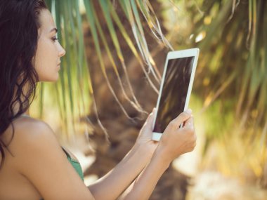 Tablet bilgisayar kullanan Gezgin kadın.