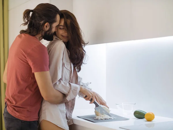 Sonriente pareja joven cocinando comida en la cocina —  Fotos de Stock