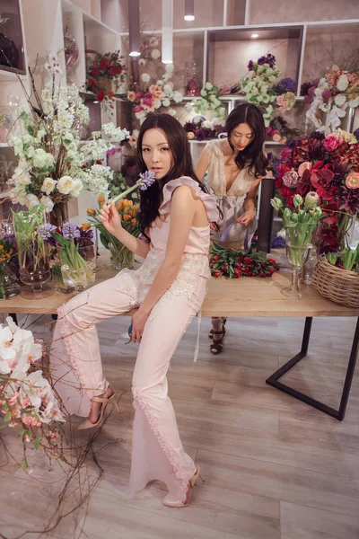 Güzel Asyalı kadınlar Çiçekçi Çiçek mağaza bir sürü bahar çiçekleri ile çalışma