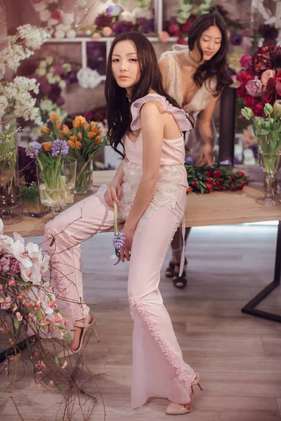 Belles femmes asiatiques fleuristes travaillant dans le magasin de fleurs avec beaucoup de fleurs de printemps — Photo