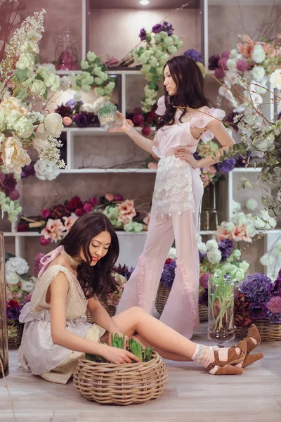 Belles femmes asiatiques fleuristes heureux de travailler dans un magasin de fleurs avec beaucoup de fleurs de printemps — Photo