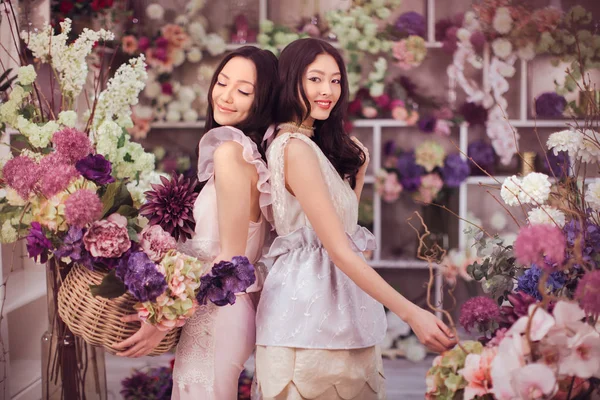 아름다운 동양인 여인들은 많은 봄 꽃을 가지고 꽃 가게에서 일하는 것을 행복하게 여긴다 — 스톡 사진