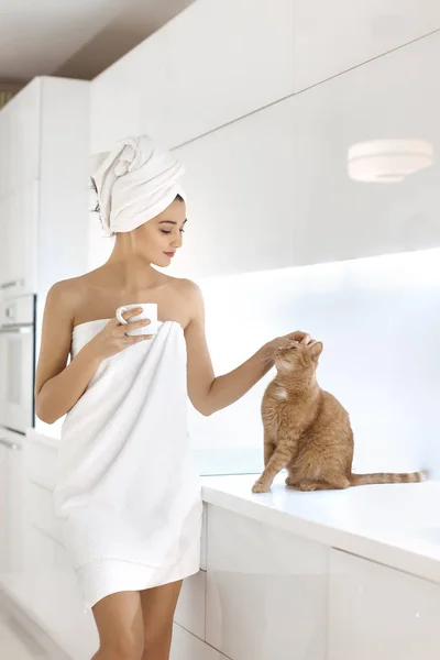 Jovem mulher em toalha desfrutando de café em casa . — Fotografia de Stock