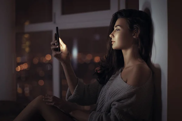 Vrouw gebruik van mobiele telefoon binnenshuis bij nacht — Stockfoto