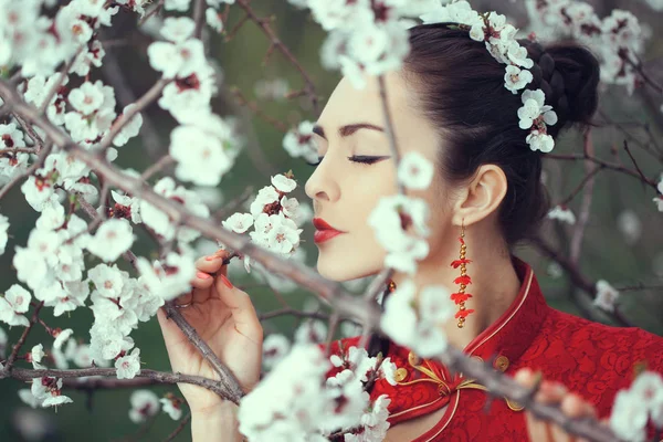 Geisha in rode kimono in sakura — Stockfoto