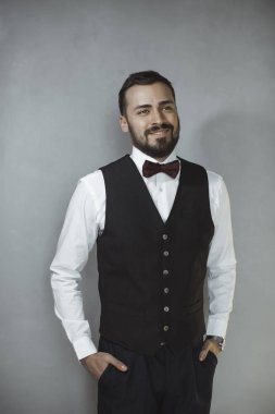 Siyah yelek ve yay kravat gülümseyen adam