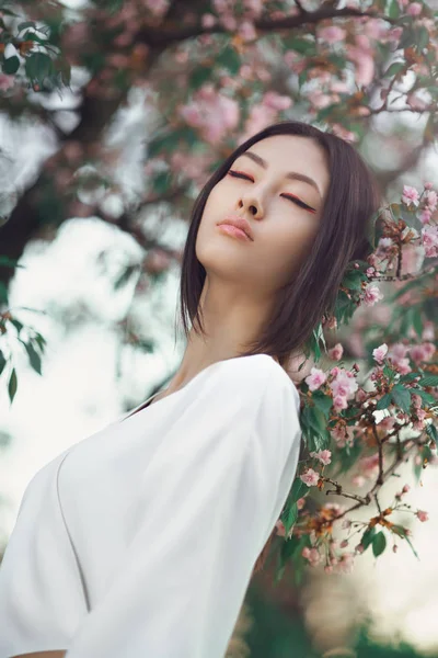 Asiática mujer al aire libre en primavera contra flor flor — Foto de Stock