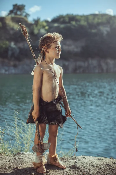 Caveman, taş balta ve yay avcılık ile erkeksi çocuk — Stok fotoğraf