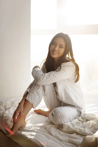 アジア人女性が家でベッドに座る — ストック写真