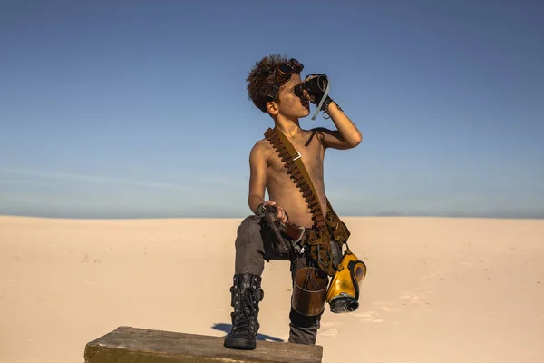 Post-apocalyptic boy outdoors in desert.