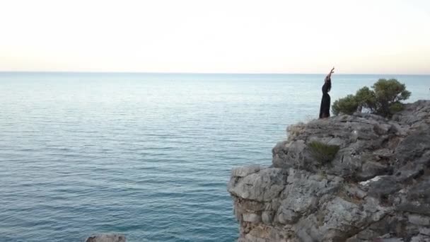 Aerial View of Young Woman on Rock Cliff Against Sea — Stock Video