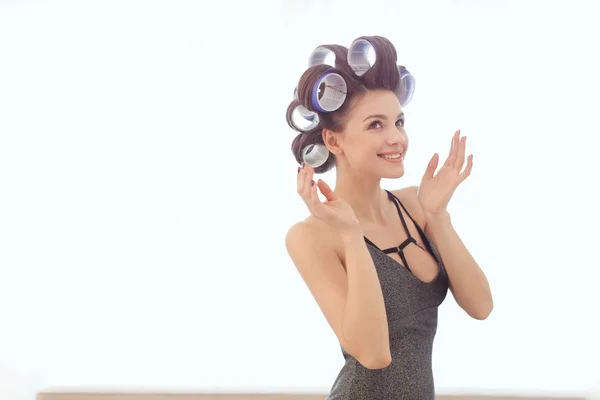 Mulher em encrespadores de cabelo dentro de casa — Fotografia de Stock