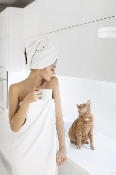 Jovem mulher em toalha desfrutando de café em casa . — Fotografia de Stock