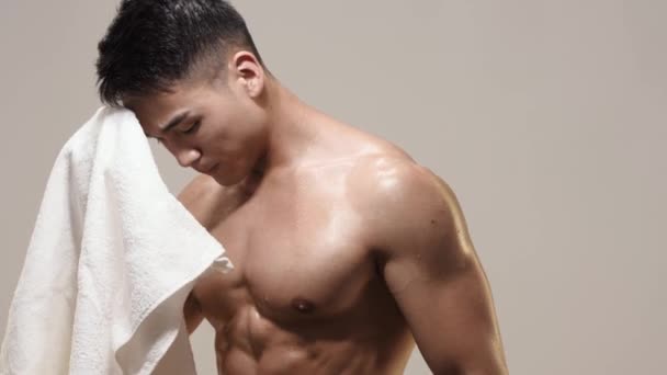 Tired Muscular Asian Man Indoors Against Gray Background