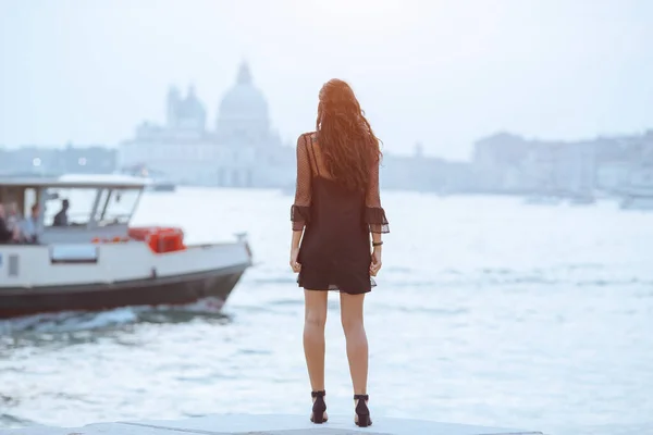 Подорожуюча туристична жінка на пірсі проти красивого видовища на венетійському шаналі у Венеції, Італія.. — стокове фото