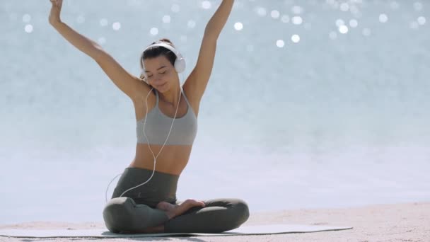 Mujer Deportiva con auriculares en la playa — Vídeos de Stock