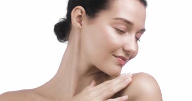 Omzunu ve çenesini okşarken gözleri kapalı bir kadının yumuşak ve huzurlu bir portresi. Lüks cilt bakımı, sağlık reklamları, kadın bakımı görselleri ve güzellik markaları için mükemmel..