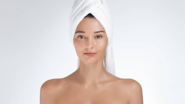 Kafasına havlu sarılmış güzel bir kadın kameraya yeni ve kendinden emin bir ifadeyle bakıyor. Stüdyo ortamlarında cilt bakımı, güzellik ve kişisel bakım için mükemmel.. 
