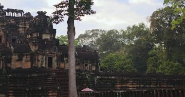 Kameralar, Kamboçya 'daki Angkor Arkeoloji Parkı' ndaki ağaçlar tarafından gizlenmiş antik Baphuon Tapınağı 'nı gösteriyor. Seyahat reklamları, tarih belgeselleri veya