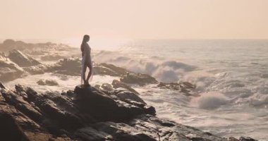 Sri Lanka 'da gün batımında uçurumun kenarında duran bir kadının nefes kesici manzarayı aydınlattığı destansı bir film. Seyahat, macera ve moda temalı yüksek kalite için ideal