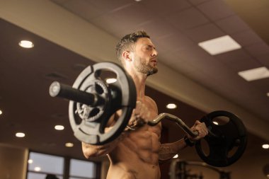 Genç atletik erkek spor salonunda ağırlık kaldırma.