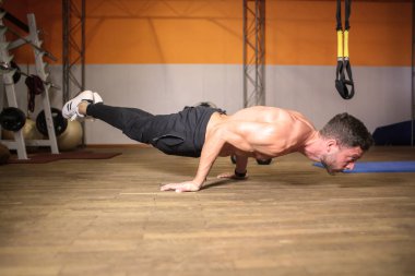 Spor salonunda egzersiz yapan genç atletik erkek.