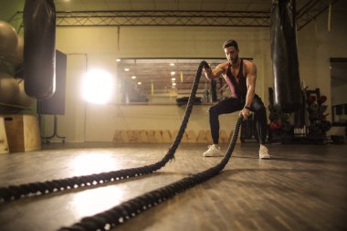 Spor salonunda egzersiz yapan genç atletik erkek.