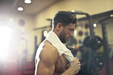Yakışıklı atletik genç adam boynuna spor salonunda bir havlu ile kararlı arıyorsunuz.