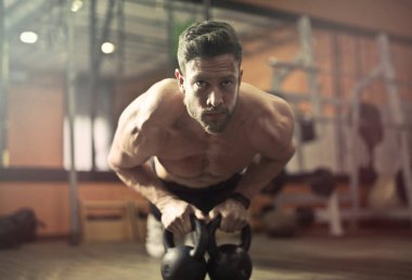 Genç yakışıklı atletik spor salonunda ağırlık çeker.